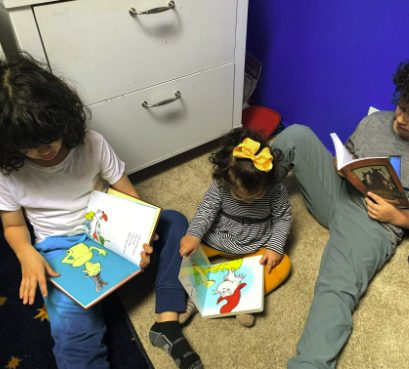 Tres niños leyendo juntos en casa