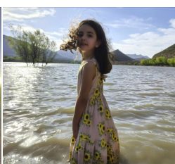 Niña explorando el río durante una salida familiar